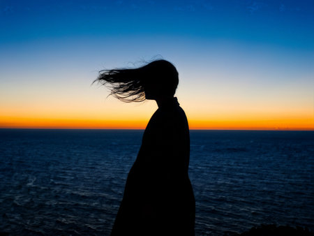 silhouette of a woman with backpack on the beachの素材