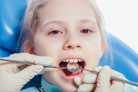 Little girl sitting in the dentists office.の写真素材