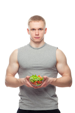 Shaped and healthy body man holding a fresh salad bowl,shaped abdominal, isolated on white background, colored retouched.の写真素材