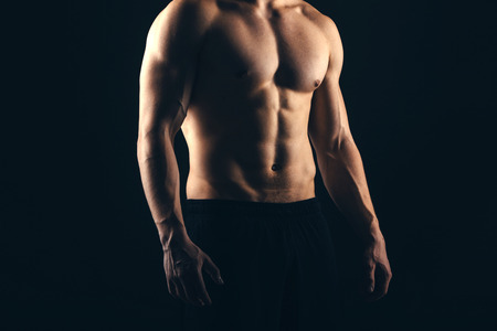 Close up of sports mans muscular back isolated on black backgroundの写真素材