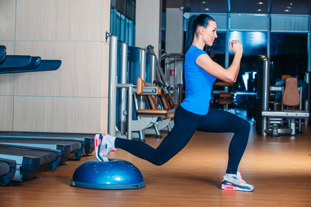 Woman making squats on balance trainerの写真素材