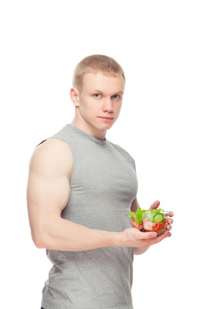 a young man with a plate of vegetable salad, isolatedの写真素材