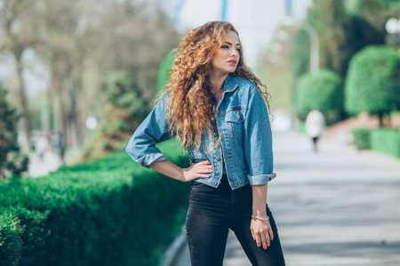 Beautiful young Caucasian girl with curly hair outdoorsの写真素材