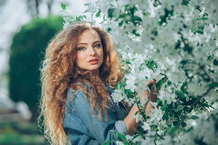 Beautiful young Caucasian girl with curly hair outdoorsの写真素材
