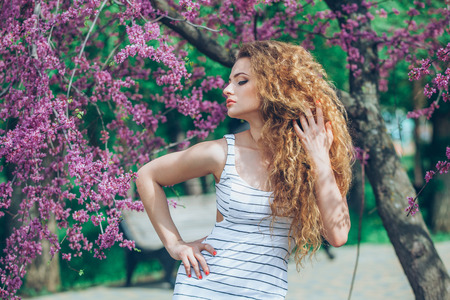 portrait of young lovely woman in spring flowersの写真素材