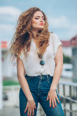 Beauty Girl Outdoors enjoying nature. Beautiful Teenage Model girl with long healthy blowing hair running on the Spring Field, Sun Light. Glow Sun. Free Happy Woman. Toned in warm colorsの写真素材