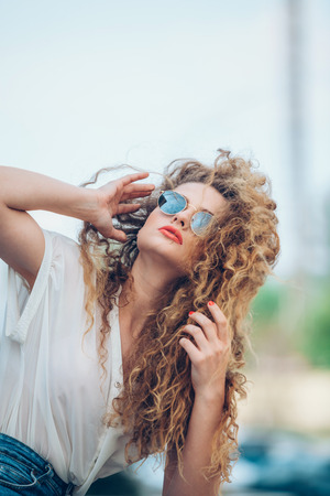 Beauty Girl Outdoors enjoying nature. Beautiful Teenage Model girl with long healthy blowing hair running on the Spring Field, Sun Light. Glow Sun. Free Happy Woman. Toned in warm colorsの写真素材
