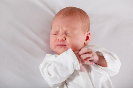 Newborn baby peacefully sleeping, on a white background