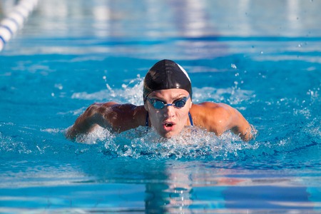 Butterfly swimmer in cap and glasses in the pool