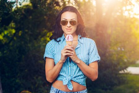 Portrait of young happy woman eating ice-cream, outdoor.