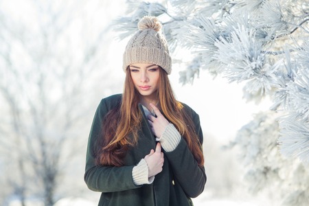 Beautiful winter portrait of young woman in the winter snowy scenery.の写真素材