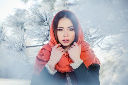 Beautiful winter portrait of young woman in the winter snowy scenery.の写真素材
