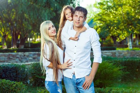 Happy family with child outdoors in jeansの写真素材