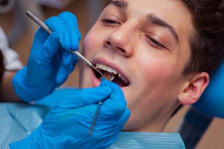Dentist treatment a patient's teeth in the dentistの写真素材