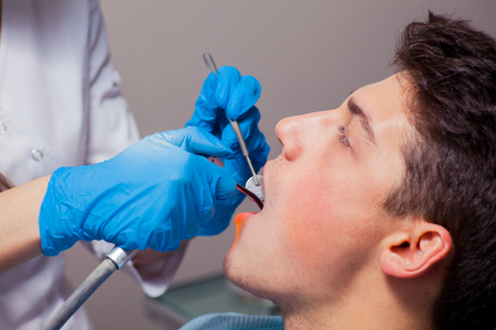 Dentist treatment a patient's teeth in the dentist.の写真素材