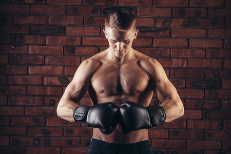 portrait of mma fighter in boxing pose against brick wall.の写真素材