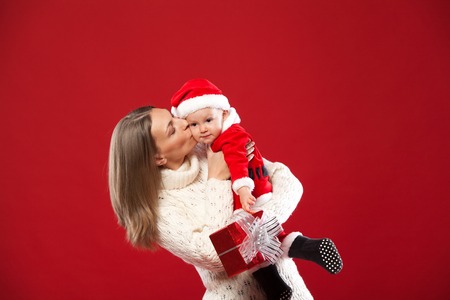 Happy young mother with her sweet baby Baby in a Christmas costume redの写真素材