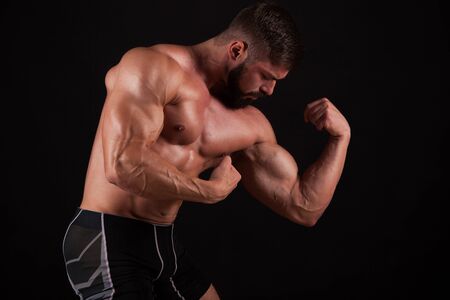 Close-up of a power fitness man's hand. Strong and handsome young bodybuilder demonstrate his muscles and bicepsの写真素材
