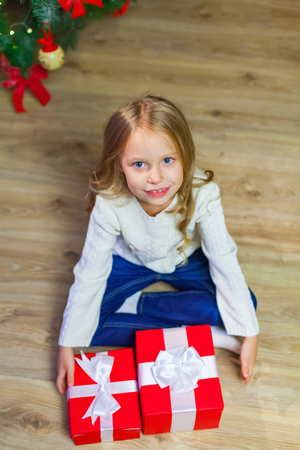 Happy little smiling girl with christmas gift box. View from aboの写真素材