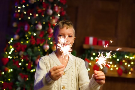 child having fun at a New Years celebration, holding sparklersの写真素材
