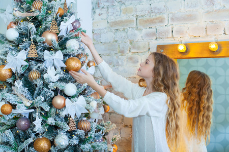 Portrait of happy girl decorating Christmas treeの写真素材