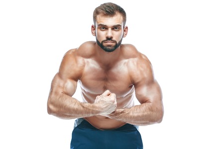 bodybuilder posing. Beautiful sporty guy male power. Fitness muscled in blue shorts. on isolated white background.の写真素材