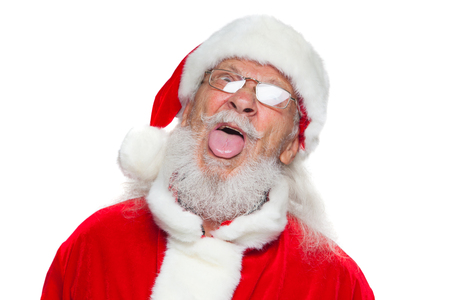 Christmas. Good Santa Claus in white gloves shows faces, grimaces, shows his tongue. Not standard behavior. Isolated on white background.の写真素材