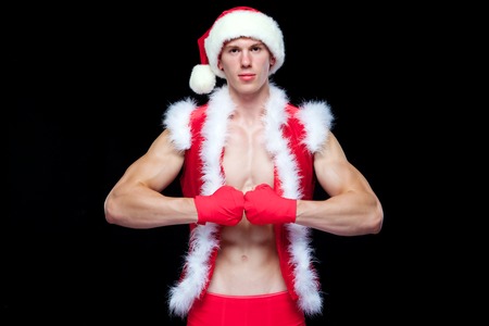 Christmas. Muscular Fighter kickbox boxing Santa Claus With Red Bandages isolated on black background.の写真素材