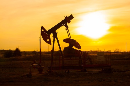 In the evening, the outline of the oil pump. The oil pump, industrial equipment. Oil field site, oil...