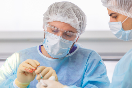 Baldness treatment. Hair transplant. Surgeons in the operating room carry out hair transplant surgery. Surgical technique that moves hair follicles from a part of the head.の写真素材