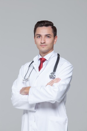 Male doctor with stethoscope standing and looking at cameraの写真素材
