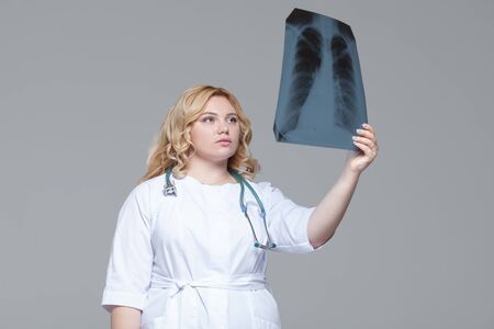 Young female doctor looking at the x-ray picture of lungs.の写真素材