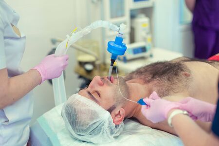 Anesthesiologist performing tracheal intubation in operation room. Preparation for surgery. Rhinoplastyの写真素材