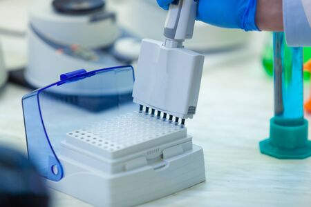 Laboratory worker puts samples into a tray making analysis for immunity viruses in a medical...