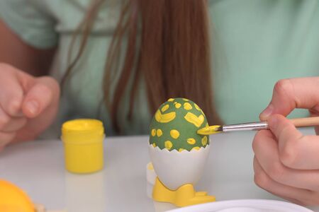 Happy easter. Girl painting Easter eggs. Happy family children preparing for Easter. Cute little child girl wearing bunny ears on Easter day Close upの写真素材