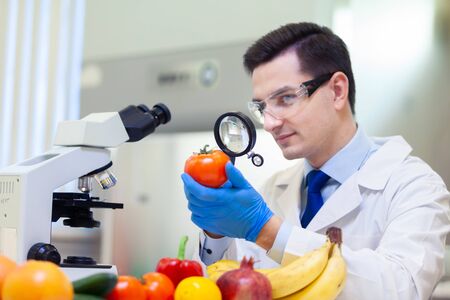 Laboratory worker examining fruits and vegetables and making analysis for pesticides and nitrates.
