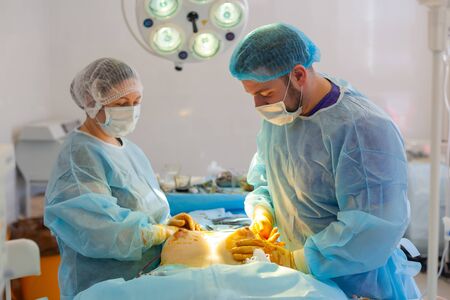 Hospital. Surgeon operates in the operating room. Completion of breast augmentation surgery.の写真素材