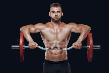 Front view of a strong man bodybuilder lifting a barbell isolated on black background
