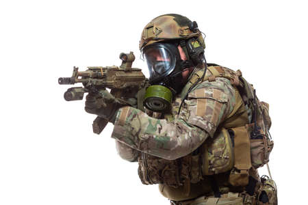 Close up portrait of special force soldier wearing military uniform, hard hat and gas mask, holding...