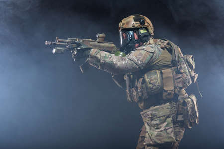 Smoke from chemical weapons and tear gas impair the visibility of a soldier in full military gear,...