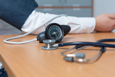 A female doctor measures the blood pressure of a male patient during a medical examination to prevent hypertension and heart attackの写真素材