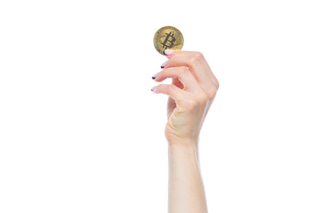 Closeup of woman hand holding physical bitcoin cryptocurrency isolated on white background. Concept...