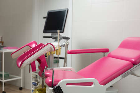 Photo of a pink gynecological chair in an equipped office of a modern medical clinicの写真素材