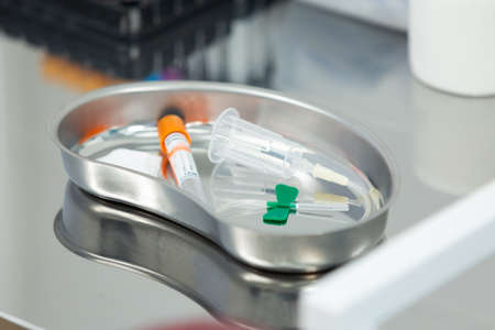 Close up of a medical tray with a syringe and test tubes for taking blood samples for analysis....