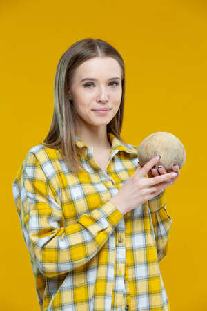 Shot of a cute young smiling woman looking at camera holding in both hands coconut isolated on...