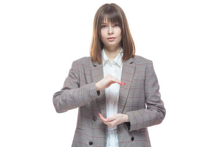 Portrait of a young woman in a jacket holding her hands in a position symbolizing the preservation of something. Template for layout. Isolated on white background.の写真素材