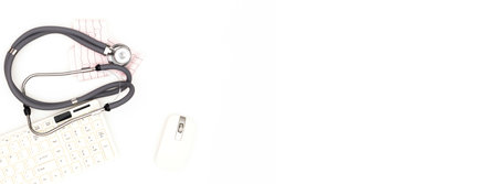 Flatlay arrangement. A stethoscope with an electrocardiogram sheet lying near a computer mouse and keyboard, isolated on a white background. Place to copy paste.の写真素材