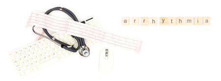 Arrhythmia. A stethoscope with an electrocardiogram sheet lying near a computer mouse and keyboard, isolated on a white background. Place to copy paste.の写真素材