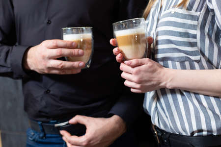 Close-up. man and woman drinking latte coffee.の写真素材