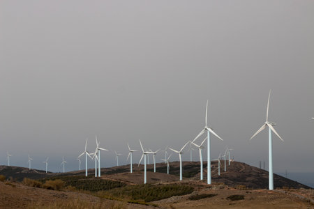 <p>windmills, on the crest of a mountain, producers of electricity, clean and renewable, on a cloudy...
